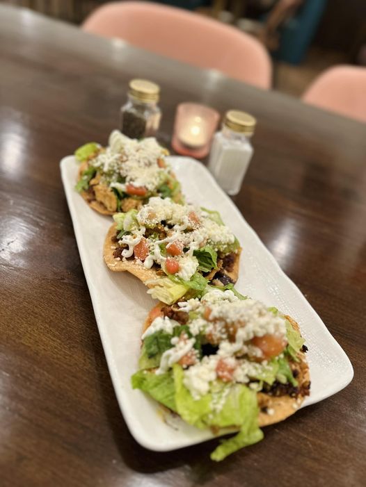 Tostadas - Homemade Tostadas w/black beans, lettuce, tomato, sour cream, guacamole, cotija cheese, chicken and chorizo